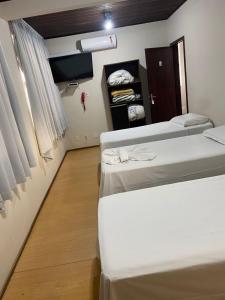 a room with three beds and a closet at Florida Confort Hotel in União da Vitória +20 photos