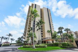 a tall building with palm trees in front of a street at Breath-taking waterfront condo with pool/spa/tennis in Marco Island