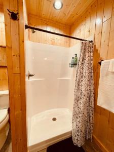a bathroom with a shower with a shower curtain at Barn On The Ridge - HOT TUB - Sleeps 6 in De Soto +23 photos