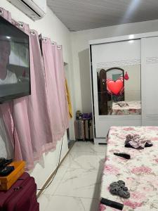 a room with a bed and a window with a heart picture at Casa para COP 30 in Ananindeua