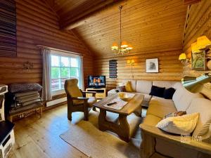 a living room with a couch and a table at Beitostølen Cabin - Sauna, large terrace and BBQ in Beitostøl