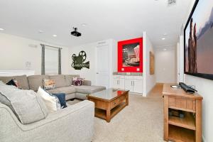 a living room with a couch and a table at Luxury Home With Themed Rooms, Game Room And Waterpark & Resort Access Near Disney At Encore Resorts Reunion - 260Cl in Kissimmee
