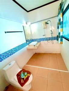 ein Badezimmer mit Toilette, Waschbecken und Spiegel in der Unterkunft Kathalee Beach Resort & Spa in Ko Lipe + 48 Fotos