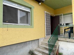 a yellow house with a balcony with a window at Yellow House in Ritopek +6 photos
