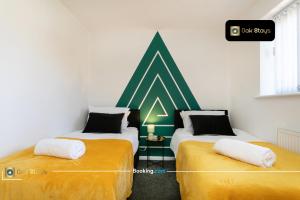 two beds in a room with a green and white wall at Quick Deals l 5 Bedroom l Sleeps 10 l Parking l Ideal for Groups l Oak Stays Short Lets & Serviced Accommodations in Churchdown