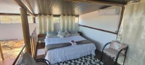 a bedroom with two beds and a chair at Chalés sol e luar in Serra do Cipo