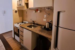 a small kitchen with a sink and a refrigerator at Hornera Eli - Steps from Oroño with parking in Rosario