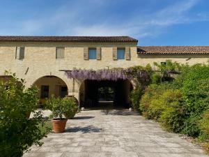 an entrance to a building with a bunch of purple flowers at a 15 min da Venezia App Rustico moderno-Treviso in Villa Cameroni