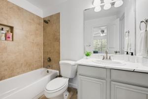 グランドプレーリーにあるTasteful 3BR I Free Parking I Workspaceのトイレと洗面台を備えた白いバスルーム +9枚の写真