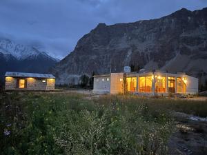 a house in a field with mountains in the background at Montvale Resort in Pasu