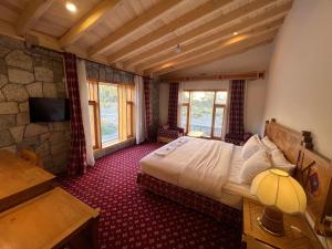 a bedroom with a bed and a desk and a television at Montvale Resort in Pasu