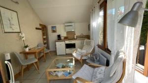 a living room with a couch and chairs and a table at L'Orme Seul, Gîte in Vineuil