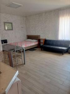 a room with a bed and a couch and a table at Одесский дворик in Zatoka