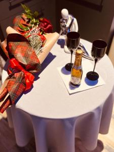 a white table with a bottle of beer and wine glasses at LOFT CON SPA PRIVATA in Santa Maria degli Angeli