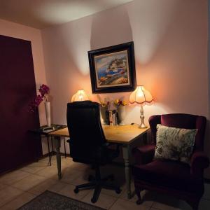 a desk with two chairs and a table with two lamps at Bekk-bur in Potchefstroom +3 photos