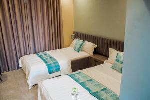una habitación de hotel con dos camas en una habitación en Maghaz Royal Hotel, en Tamale