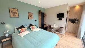 a bedroom with a blue bed with two pillows at Le Lodge d'Amélie in Diémoz