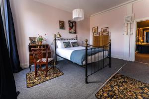 a bedroom with a bed and a table and a chair at Rooms & Apartments Malone Road in Belfast