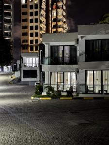 a large white building at night with tall buildings at Jumeriah palms resort in Mombasa