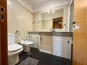 a bathroom with a toilet and a sink and a mirror at Sea Soul residencial in Funchal +19 photos