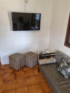 Una sala de estar con dos sofás y un televisor de pantalla plana. en Hostel Sepumpá Sepápum, en Itanhaém