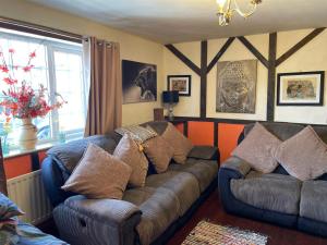 a living room with a couch with pillows on it at Hayloft Sleep 2 NeXT to Fox Covert Pub in Kirk Leavington