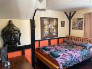 a bedroom with a bed and a statue of a head at Hayloft Sleep 2 NeXT to Fox Covert Pub in Kirk Leavington