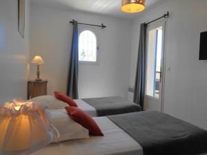 a hotel room with two beds and a window at Clos des Lavandes - Chambres et Suites de charme climatisées-Luberon in Lacoste