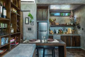 a kitchen with a table and a refrigerator at Riptide Lodge in El Paredón Buena Vista +24 photos