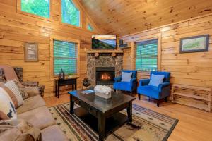 a living room with a fireplace and blue chairs at Rosey Bear cabin in Pittman Center +28 photos