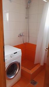 a washing machine in a bathroom with a shower at Apartments Foco in Sarajevo
