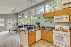 a kitchen with wooden cabinets and appliances and windows at Appalachian Mtn Retreat 4 Mi to Grovewood Village in Asheville