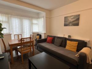 a living room with a couch and a table at 3 Bedroom modern house 15 min to tube, shops near by in Finchley