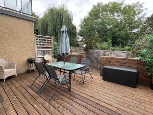 a patio with a table and chairs and an umbrella at 3 Bedroom modern house 15 min to tube, shops near by in Finchley +13 photos