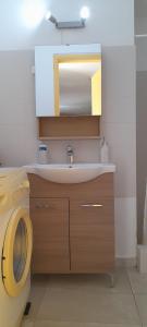 a bathroom with a sink and a mirror at Cosy guest house with private yard in Saronida