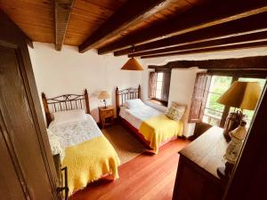 a bedroom with two beds and a window at HdeC Hosteria de Castañeda Alojamiento Turistico in Puente Viesgo