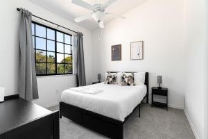 a white bedroom with a bed and a window at Remodeled Townhome with Pool & Lake Views in Gated in Delray Beach