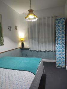 a bedroom with a bed with a blue sheet on it at Casa Aloha Barra in Maricá