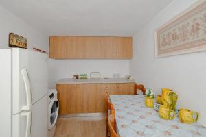 een keuken met een tafel en een witte koelkast bij Statis House in Lardos