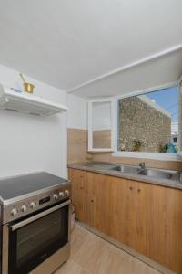 een keuken met een fornuis, een wastafel en een raam bij Statis House in Lardos