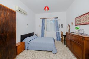 een slaapkamer met een bed, een dressoir en een bureau bij Statis House in Lardos