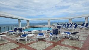 a balcony with chairs and a swimming pool on a cruise ship at Solarium Studio Apartment at Coronado Bay Oceanfront in Playa Coronado