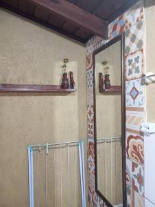 a bathroom with a mirror and shelves on the wall at Hibisco Rosa Aluguéis in Araçatuba +35 photos
