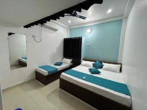 a bedroom with two beds and a mirror at Shree Gomukh residency comfortable home stay for family near to vishwanath temple 200 mtrs in Varanasi