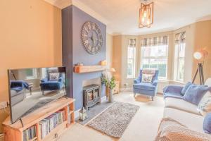 a living room with a large clock on the wall at Coastal home sleeping five - 2 minute walk beach in Pakefield