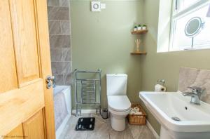 a bathroom with a toilet and a sink at Coastal home sleeping five - 2 minute walk beach in Pakefield +28 photos