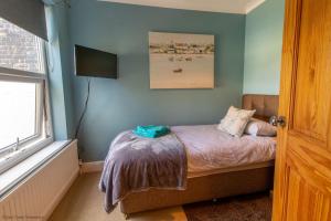a small bedroom with a bed and a window at Coastal home sleeping five - 2 minute walk beach in Pakefield