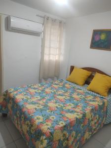 a bedroom with a bed with a colorful quilt at Enseadas dos corais in Cabo de Santo Agostinho