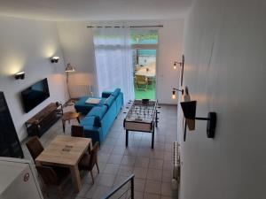 a living room with a blue couch and a table at Factory's room in Montbertrand