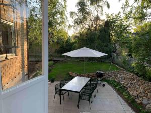Una mesa y sillas con una sombrilla en un patio. en Large flat with own patio, en Nacka 15 fotos más